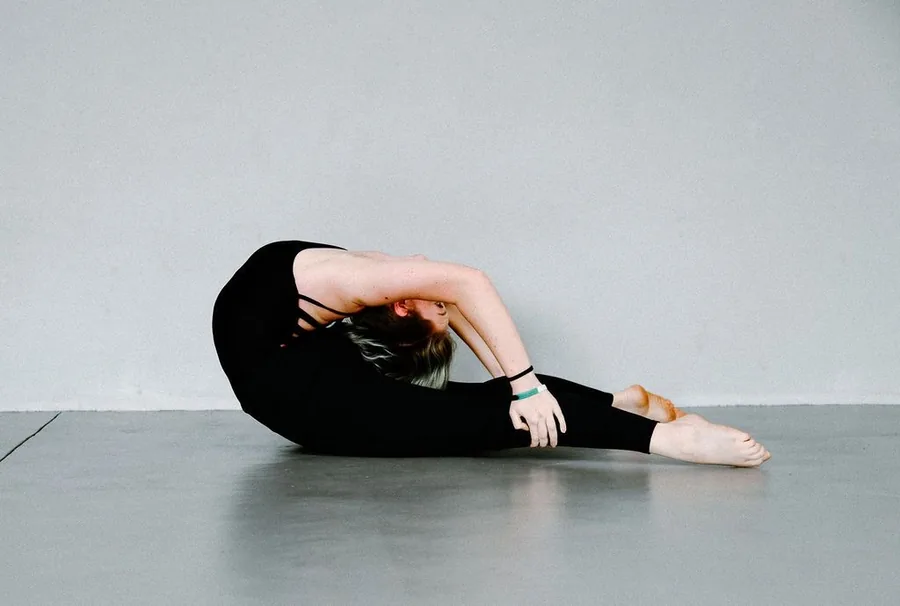 Thalia folded into a deep backbend on a studio floor